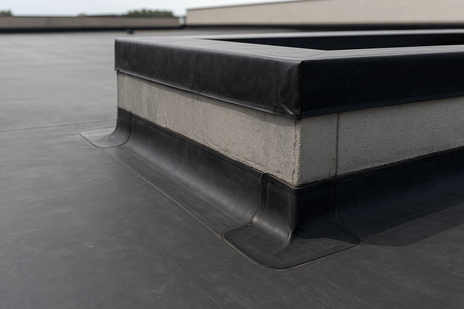 a close-up of EPDM rubber membrane and flashing details around a rooftop curb on a commercial building — commercial roofing
